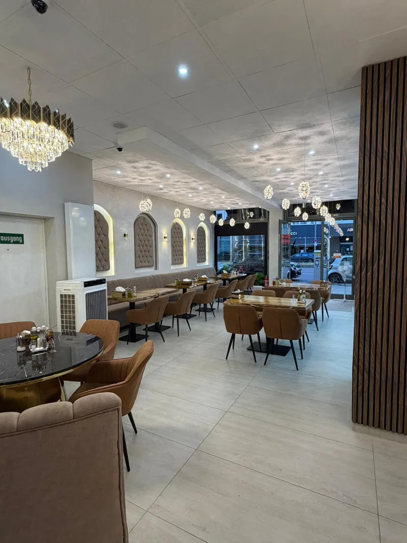 Innenraum des Café de Sammont — elegante Kristallleuchten, gemütliche Sitzreihen