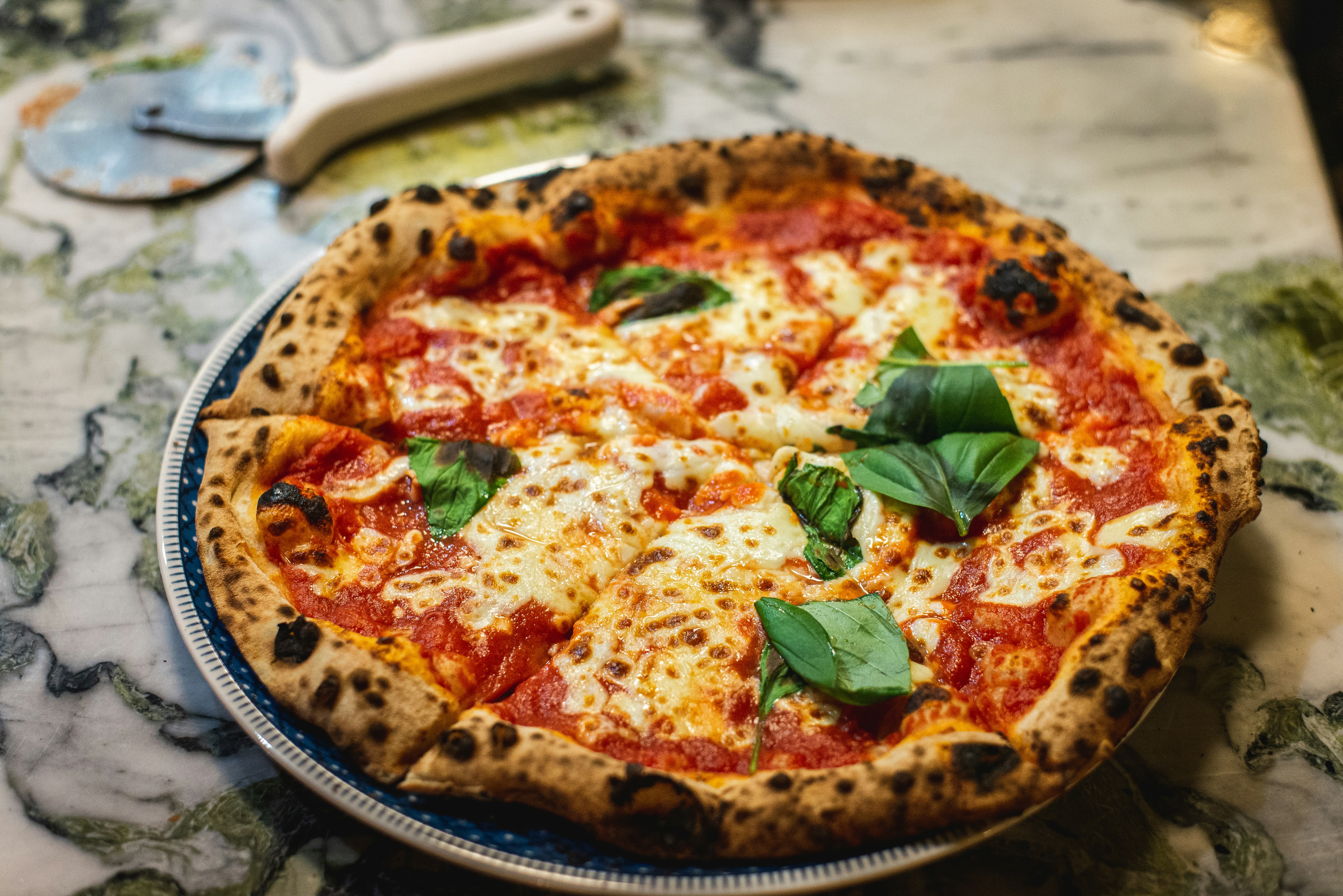 Pizza Margherita mit frischem Basilikum und Büffelmozzarella